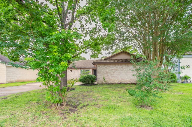 a view of a house with a tree and a yard