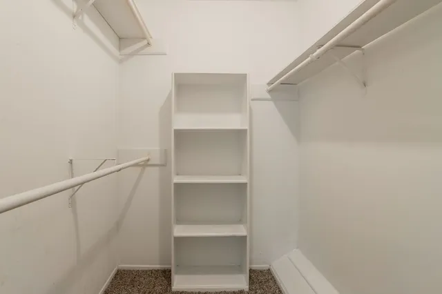 a view of walk in closet with empty racks