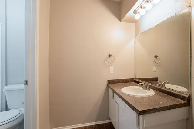 a bathroom with a granite countertop sink and a mirror