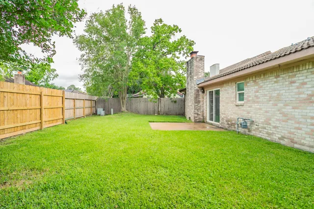 a view of a backyard with a garden and entertaining space