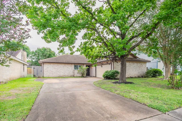 a front view of a house with yard and tree