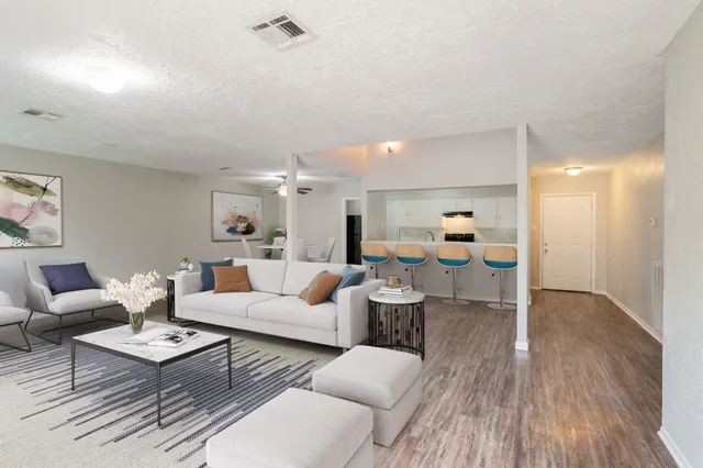 a living room with furniture and view of kitchen