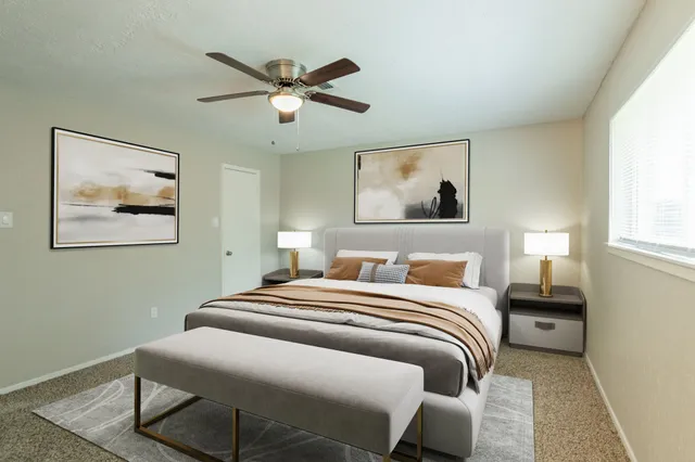 a bedroom with a bed and a painting on the wall