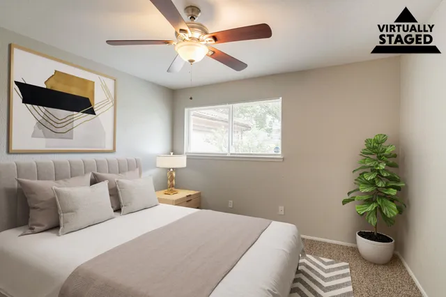 a bedroom with a large bed and a potted plant