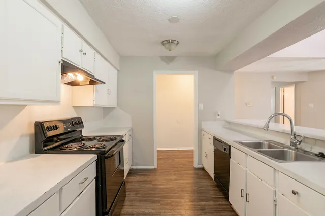a kitchen with a sink stove and cabinets