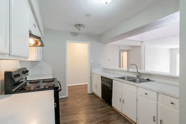 a kitchen with a sink stove and cabinets