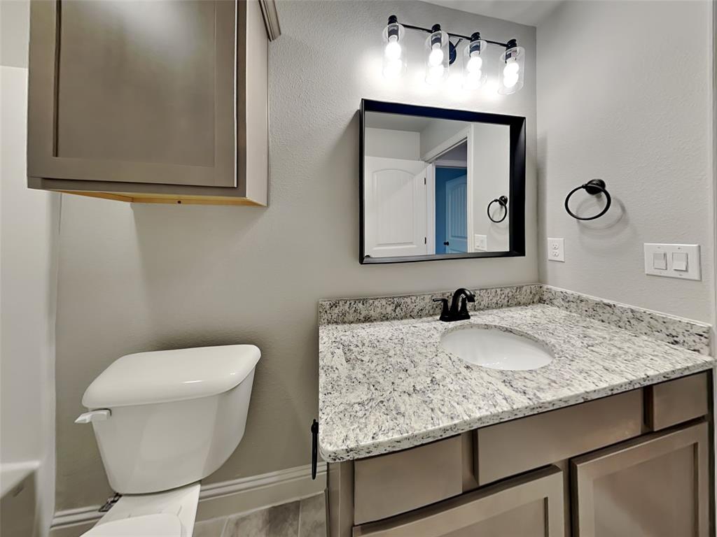 2108 Gabriel Drive Sherman, TX 75092 - Photo 14 of 16 a bathroom with a toilet sink and mirror