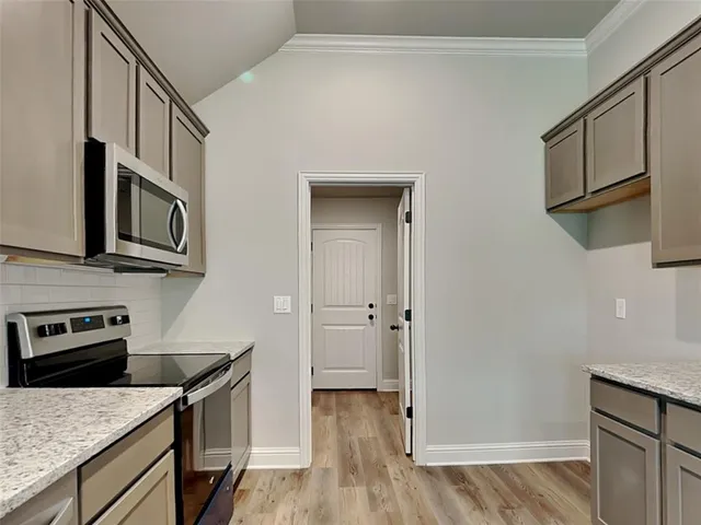 a kitchen with stainless steel appliances granite countertop a refrigerator a stove top oven a sink and dishwasher