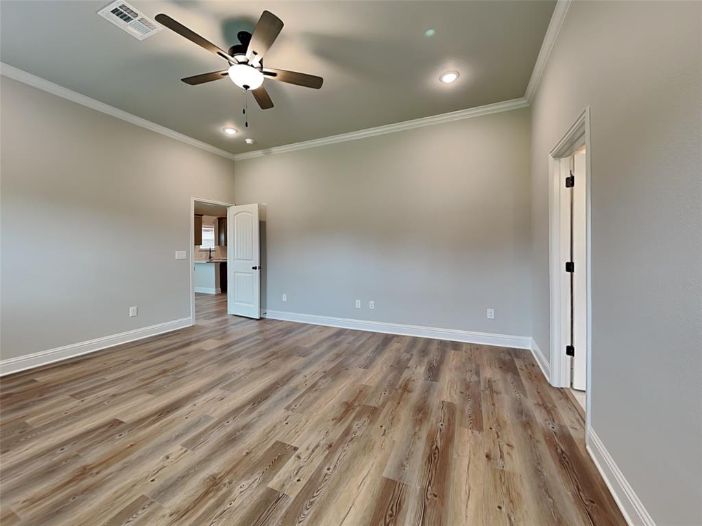 2108 Gabriel Drive Sherman, TX 75092 - Photo 7 of 16 an empty room with wooden floor and a ceiling fan