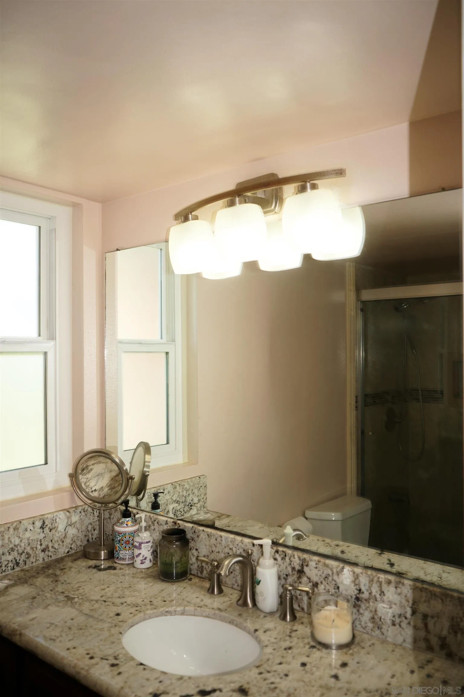 7842 Hemphill Drive San Diego, CA 92126 - Photo 16 of 29 a bathroom with a granite countertop sink and a mirror