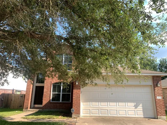 a view of a yard in front of a house with large tree