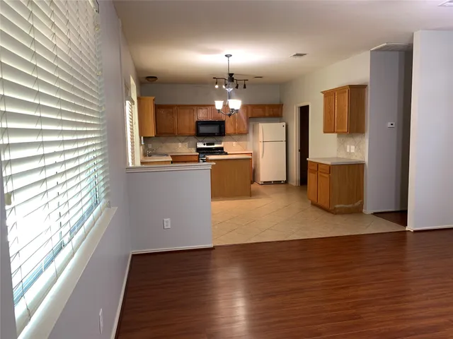 a kitchen with a sink a stove cabinets and a window
