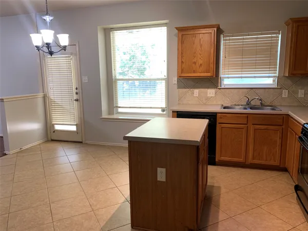 a kitchen with a sink a stove cabinets and a window