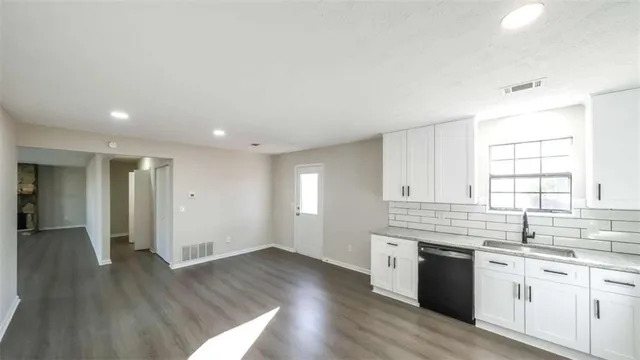 a kitchen with granite countertop a stove and a sink