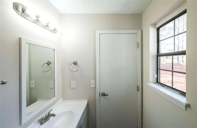 a bathroom with a tub shower vanity and a sink