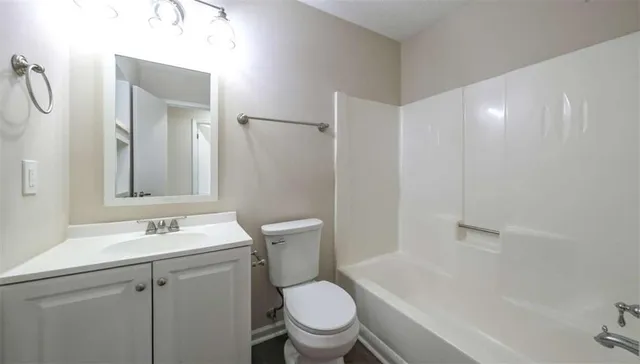 a bathroom with a granite countertop sink toilet a mirror and shower