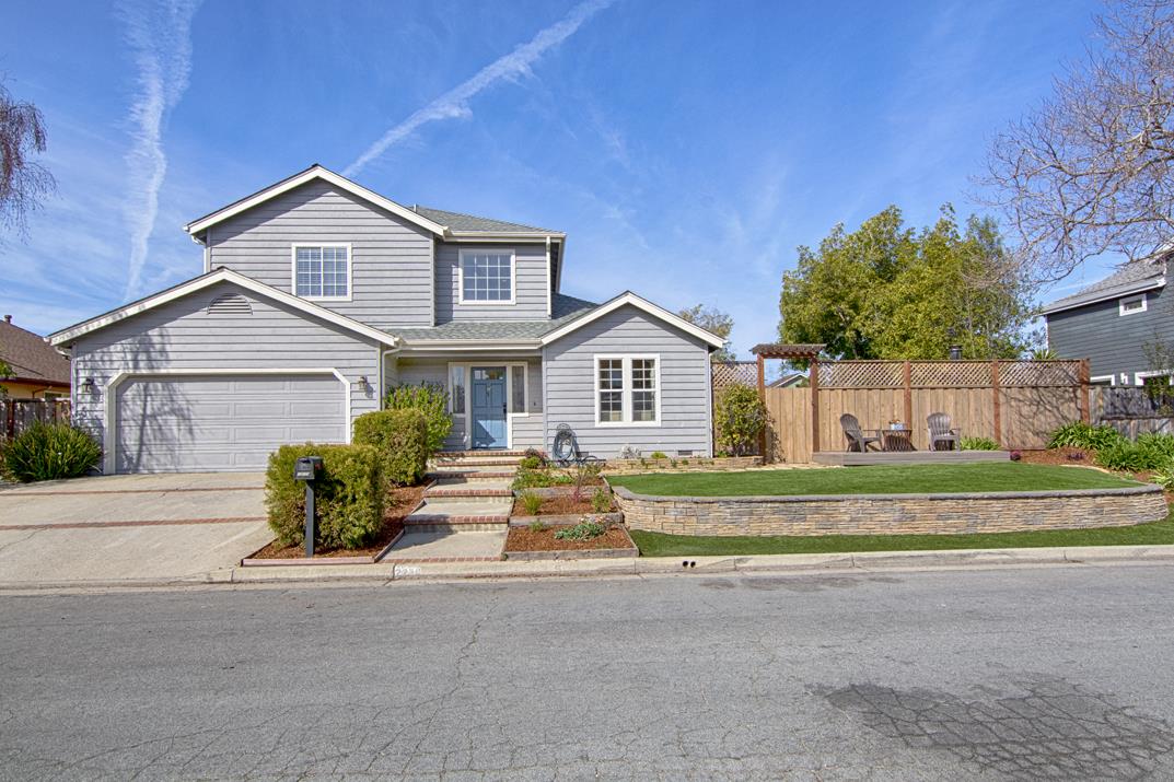 a front view of a house with a yard and trees