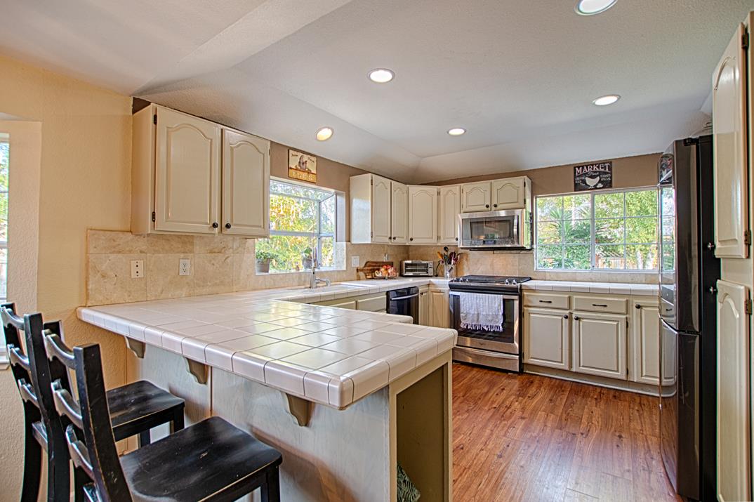 2230 Albert Lane Capitola, CA 95010 - Photo 11 of 34 a kitchen with a stove a sink dishwasher a refrigerator with white cabinets and wooden floor