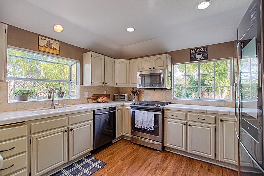 2230 Albert Lane Capitola, CA 95010 - Photo 14 of 34 a kitchen with white cabinets appliances a sink and a large window