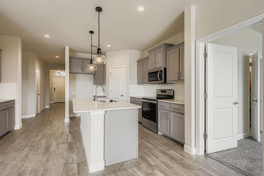 1829 Ruffian Road Granbury, TX 76049 - Photo 11 of 39 a kitchen with kitchen island a sink stainless steel appliances and cabinets
