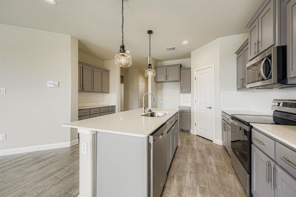 1829 Ruffian Road Granbury, TX 76049 - Photo 12 of 39 a kitchen with stainless steel appliances granite countertop a sink stove and refrigerator