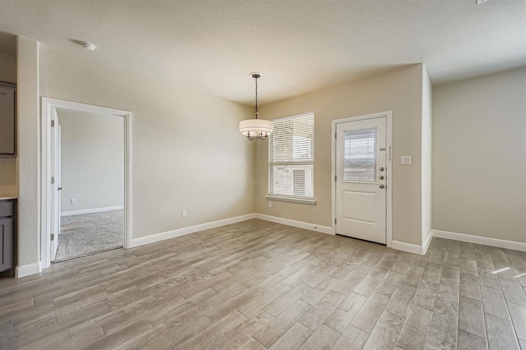 1829 Ruffian Road Granbury, TX 76049 - Photo 13 of 39 an empty room with wooden floor and cabinet