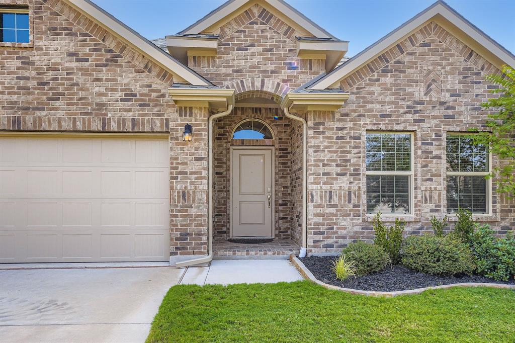 1829 Ruffian Road Granbury, TX 76049 - Photo 4 of 39 a front view of a house with a garden