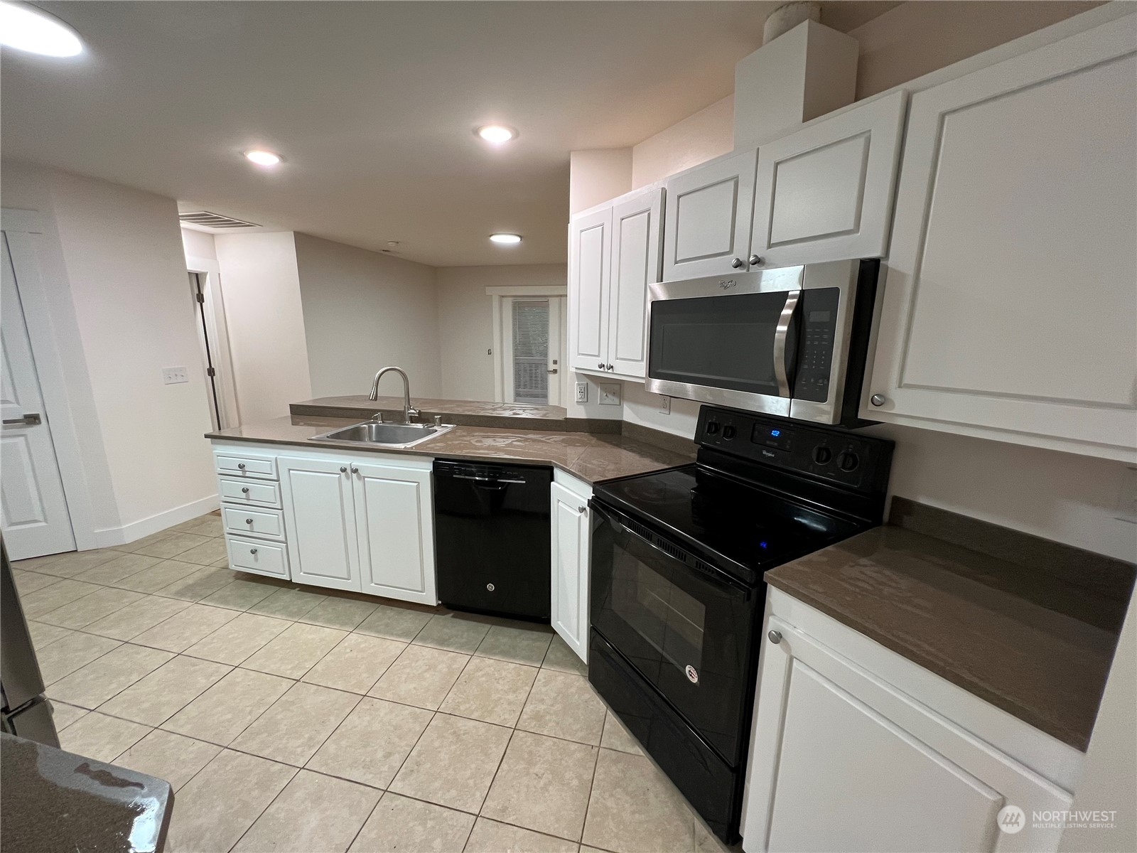 8229 South 132nd Street Seattle, WA 98178 - Photo 6 of 15 a kitchen with a sink a stove and cabinets