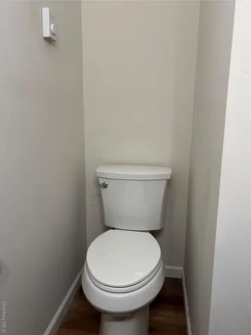 a white toilet sitting next to a white wall