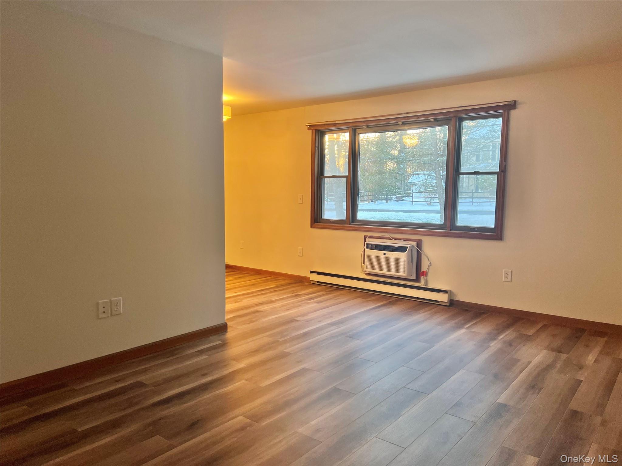 188 River Road, Unit B Wallkill, NY 12589 - Photo 3 of 20 a view of an empty room with wooden floor and a window