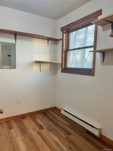 a view of empty room with wooden floor and fan