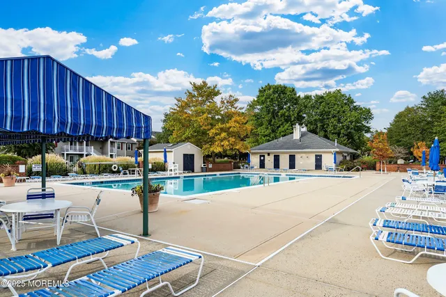 a view of swimming pool with seating area and barbeque oven