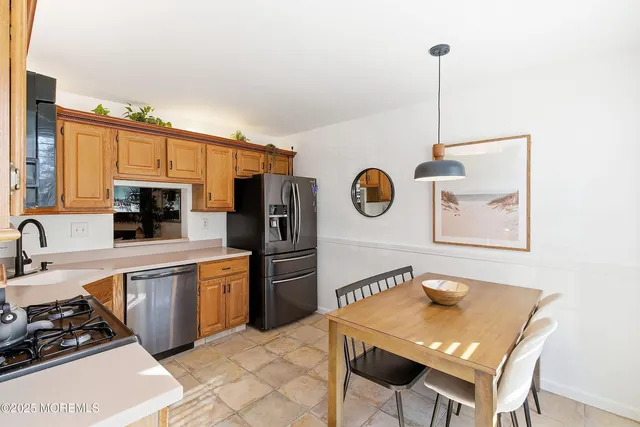 a kitchen with stainless steel appliances granite countertop a refrigerator a stove and a wooden floor