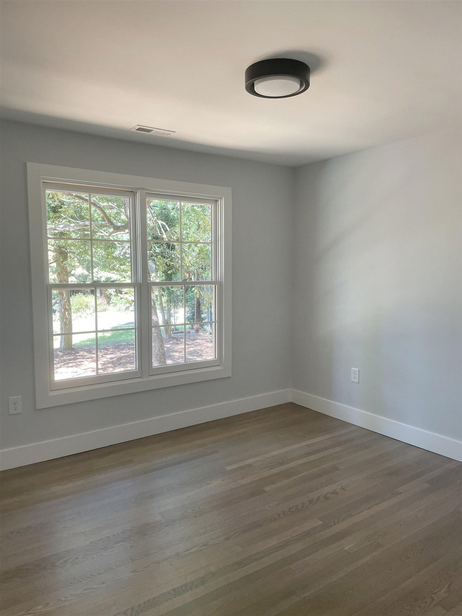 245 Marilyn Circle Cary, NC 27513 - Photo 18 of 21 an empty room with wooden floor and windows