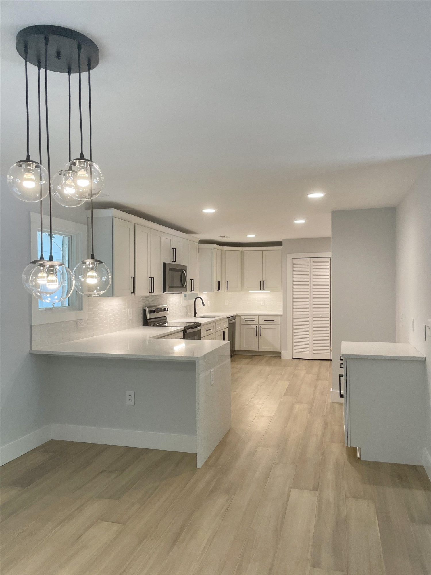 245 Marilyn Circle Cary, NC 27513 - Photo 7 of 21 a view of a kitchen with kitchen island a sink wooden floor and a counter top space