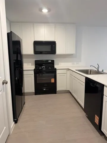 a kitchen with stainless steel appliances a refrigerator sink and microwave