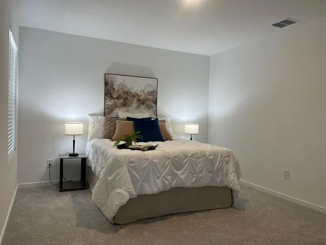 a bedroom with a bed and lamp