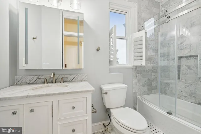 a bathroom with a granite countertop toilet sink and a bathtub
