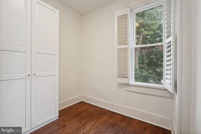 a view of a small space with wooden floor and a window
