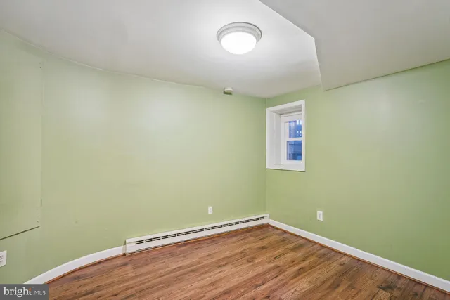 a view of a room with wooden floor and a window