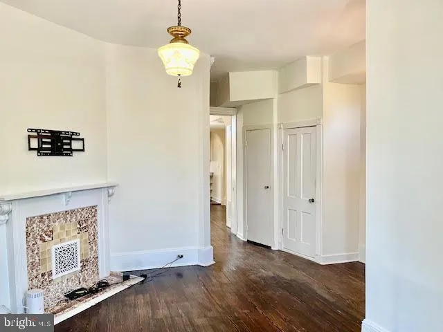 a view of a hallway with wooden floor and chandelier
