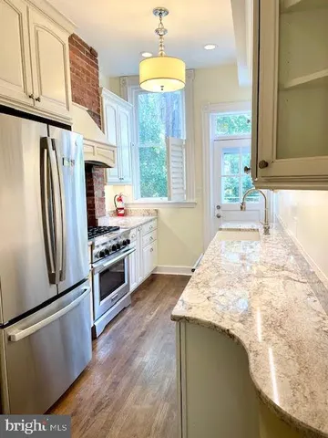 a kitchen with stainless steel appliances a refrigerator a stove and a refrigerator