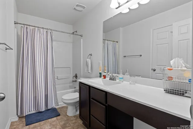 a bathroom with a sink a toilet and a large mirror