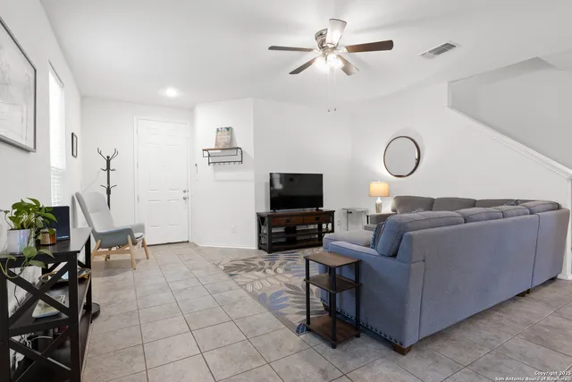 a living room with furniture a flat screen tv and a fireplace