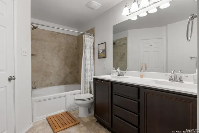 a bathroom with a double vanity sink toilet and shower