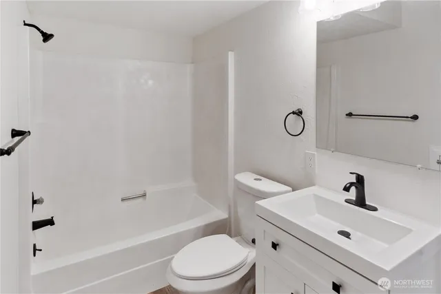 a white toilet sitting next to a bath tub