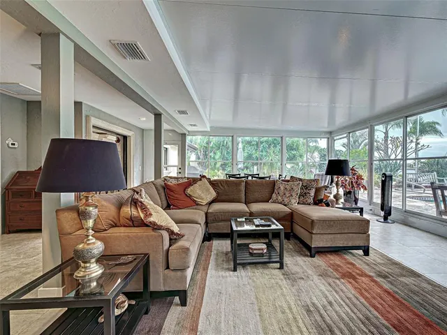 a living room with furniture a flat screen tv and a floor to ceiling window