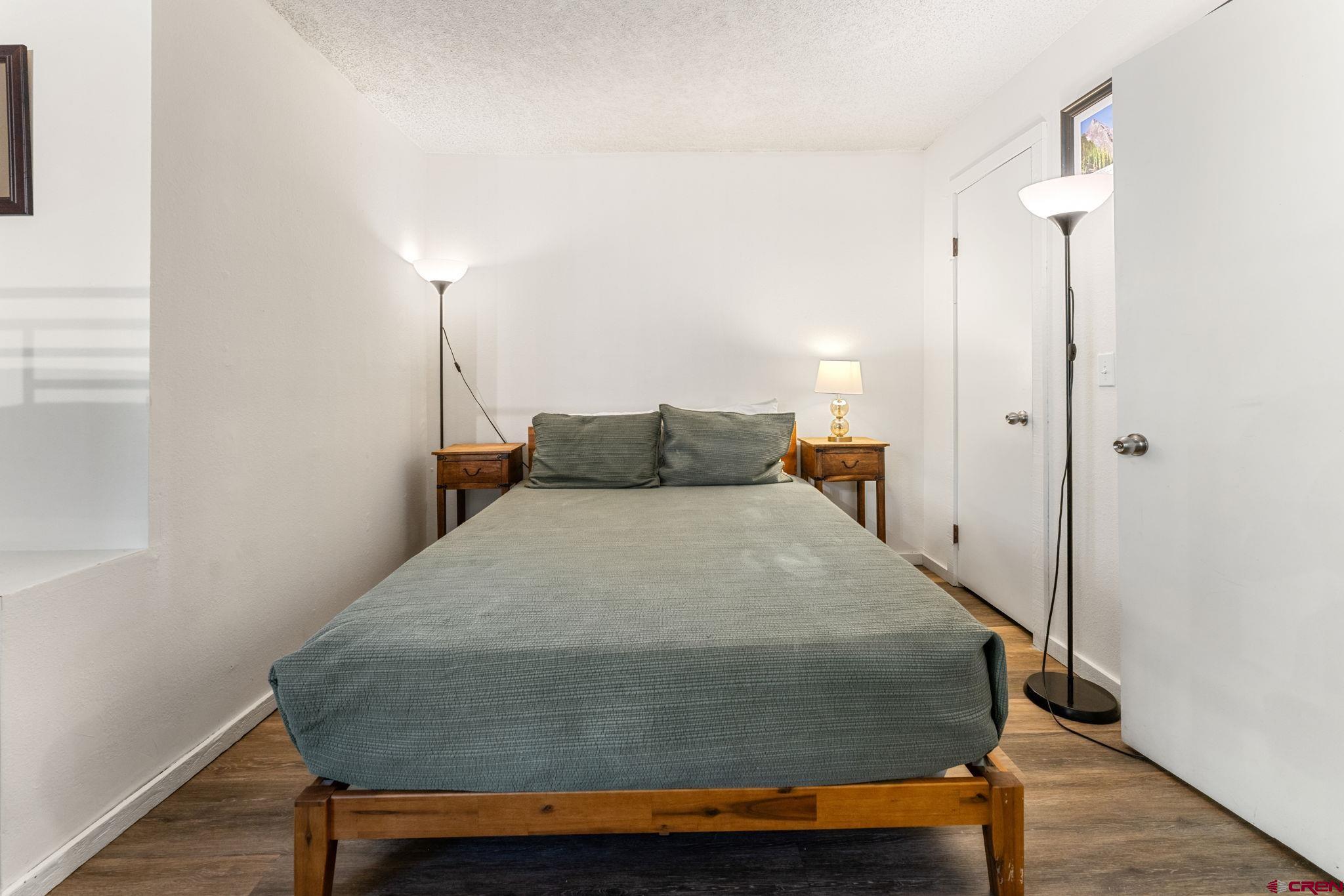 72 Hunter Hill Road, Unit I204 Crested Butte, CO 81225 - Photo 23 of 44 a bedroom with a bed and wooden floor