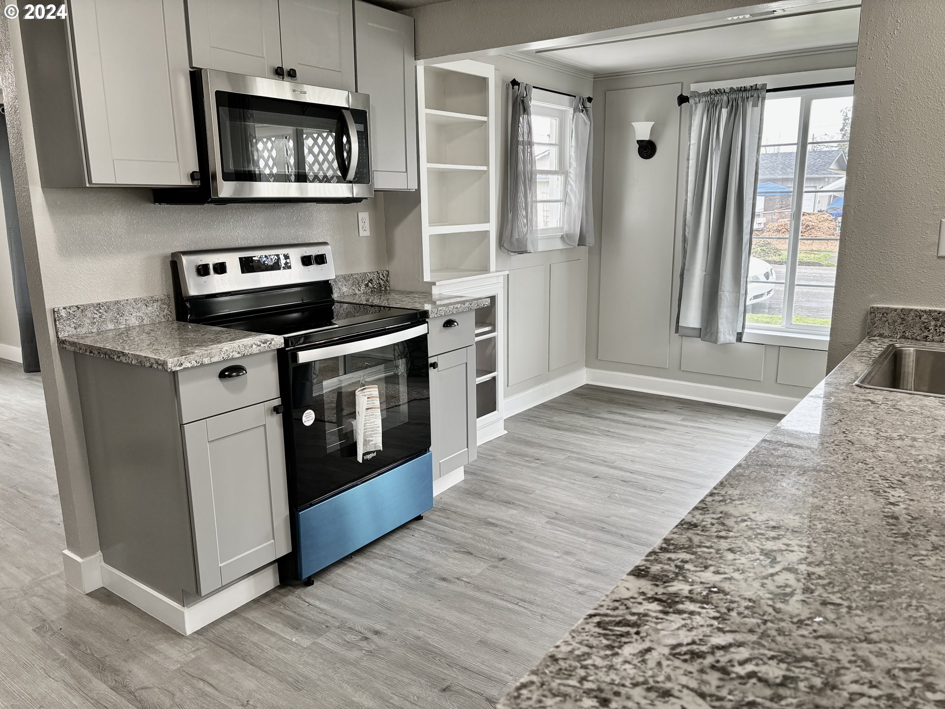 545 22nd Street Springfield, OR 97477 - Photo 3 of 25 a kitchen with stainless steel appliances granite countertop a stove a sink and a microwave