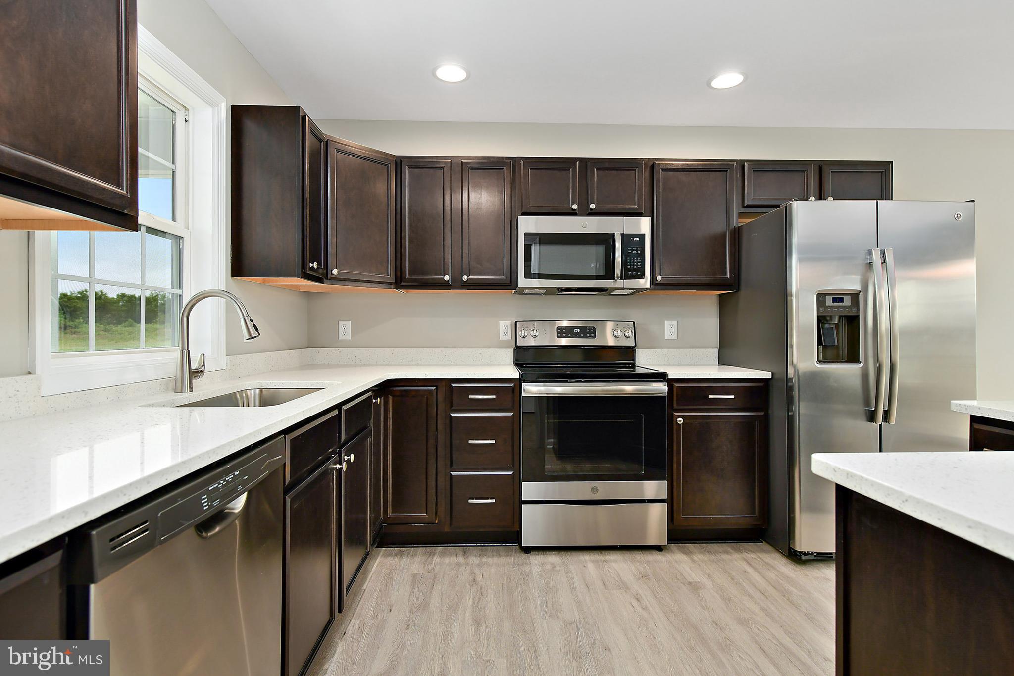 153 Fooks Road Bishopville, MD 21813 - Photo 10 of 30 a kitchen with stainless steel appliances wooden cabinets and granite counter tops